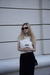 a lady in a beige T-shirt and a black skirt with a belt